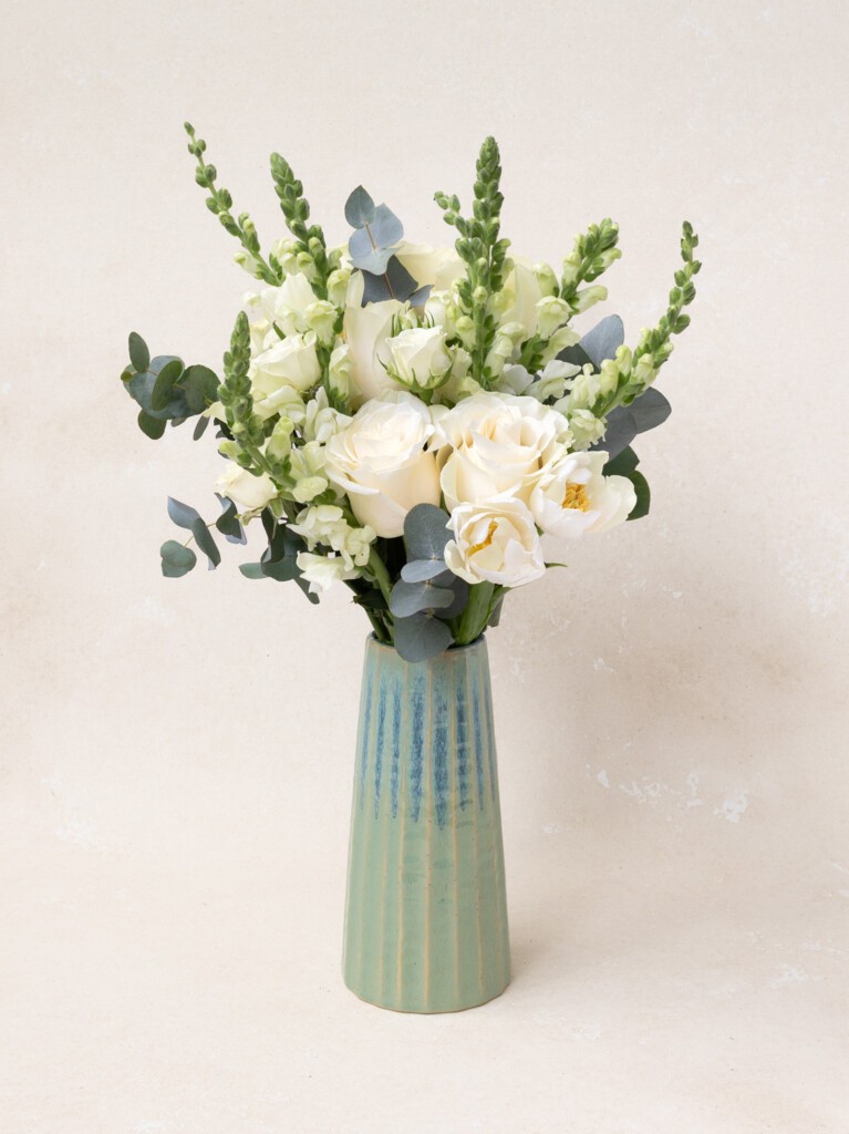 Paulette bouquet with 16 stems of white snapdragons, roses, tulips, and eucalyptus. A serene, premium arrangement ideal for thank yous or housewarmings.