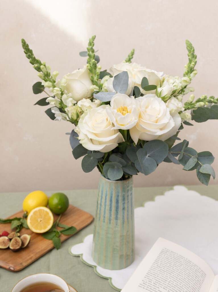 Paulette 16-stem white flower arrangement styled with fruit and tea. Elegant gift idea for housewarmings, bridal brunches, or serene mornings at home.