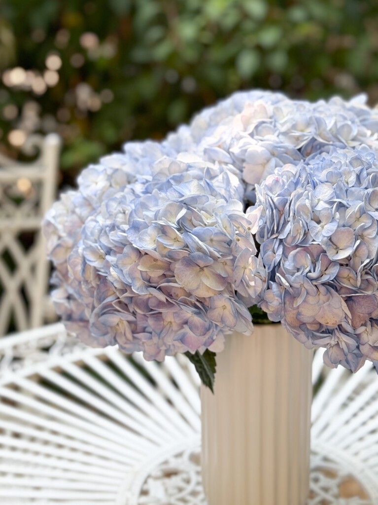 Close-up shot of Blue Hydrangea bouquet on white garden table