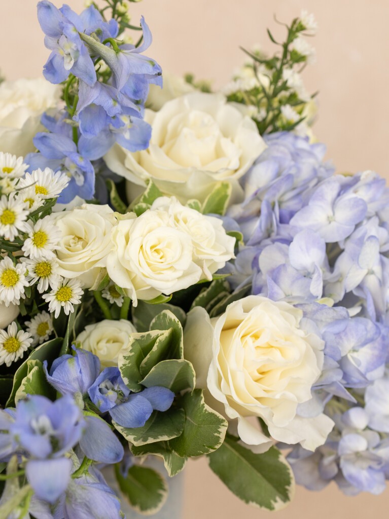 Close-up of Enora bouquet.  Mixed coastal bouquet featuring blue hydrangeas, white roses & more